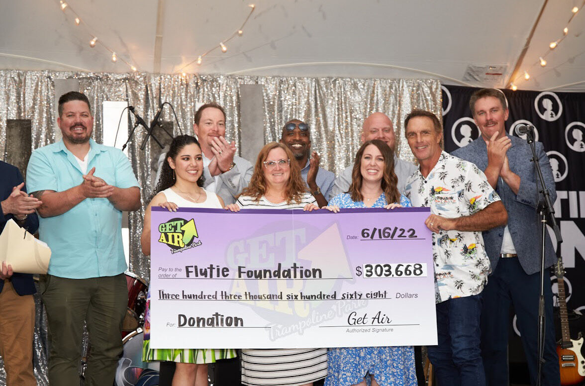 People posing with flutie foundation donation check